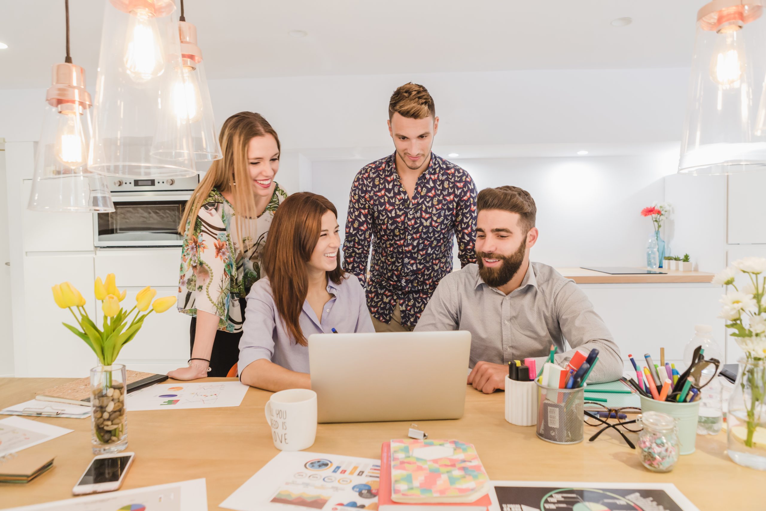 cheerful-team-workers-with-laptop