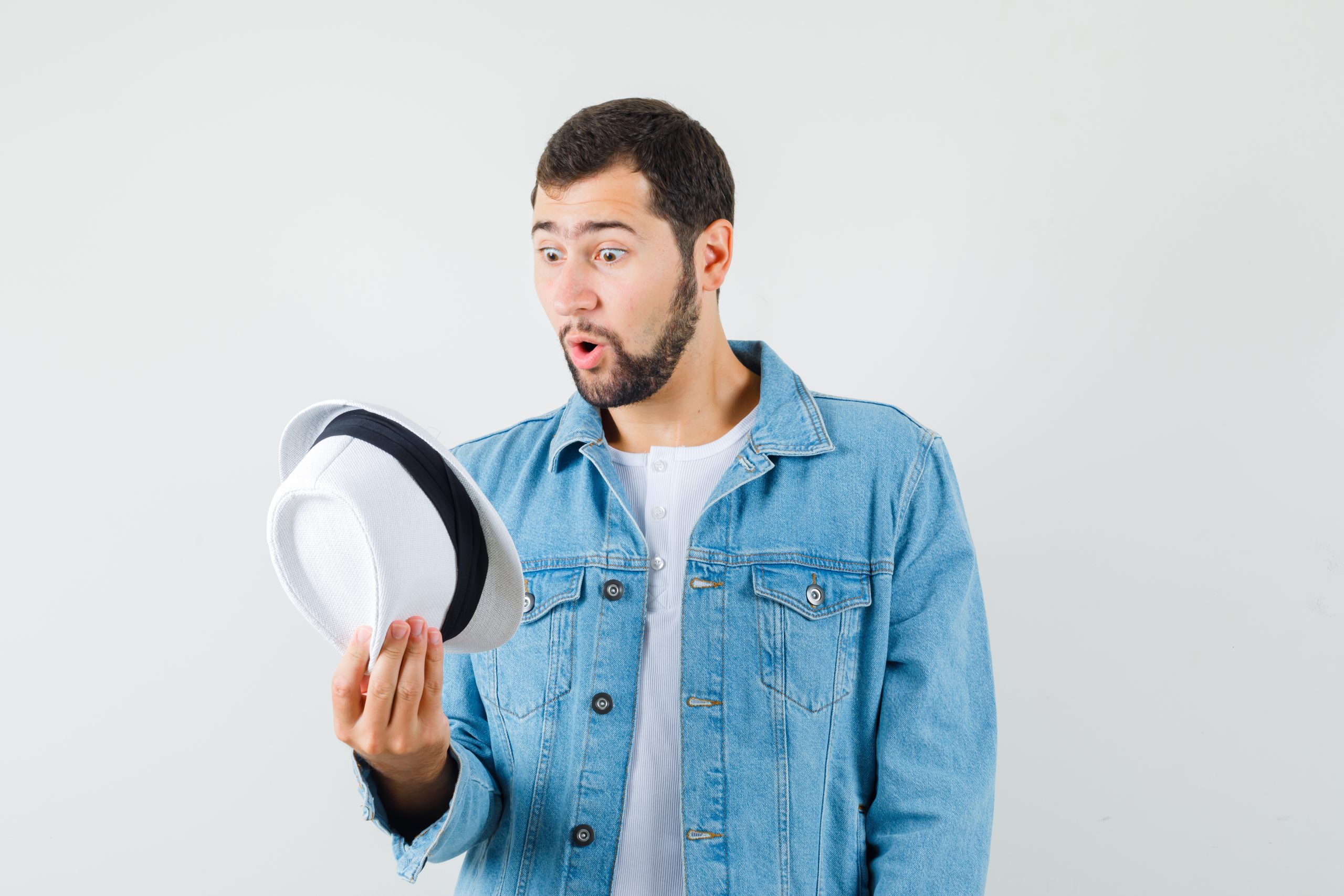 Retro-style man looking inside the hat in jacket,t-shirt and looking dumbfounded. front view.